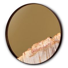 a round mirror with an image of a mountain in the middle and gold paint on it