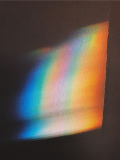 an image of a rainbow colored light coming out of a window