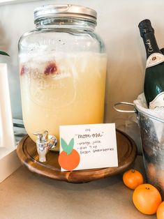 a bottle of wine and some oranges on a table with a sign that says new year's eve