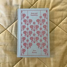 a book sitting on top of a bed next to a quilted comforter with red and white flowers