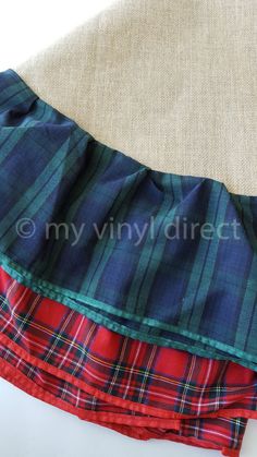 three different plaid fabric pieces are stacked on top of each other, one is red and the other is blue