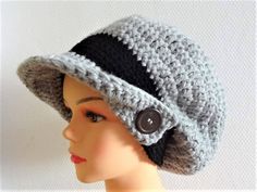 a mannequin head wearing a crocheted hat with buttons on the brim