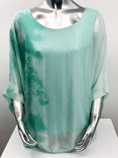 Imagine wearing this incredible top at an outdoor party or out to dinner with friends. A glorious flowy fabrication creates a stunning tunic in a mint tie dye pattern.  Create a classy and fashion forward look with this tunic by pairing it with white bottoms or black slacks. Flowy Summer Tunic Top, Long Sleeve Tie Dye Blouse For Summer, Green Flowy Tunic For Spring, Spring Vacation Green Tunic, Green Casual Tunic For Spring, Casual Green Tunic For Spring, Green Tunic Tops For Summer, Green Short Sleeve Tunic For Summer, Green Tunic Tops For Spring