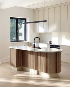 an image of a kitchen setting with white cabinets and wood accents on the countertops