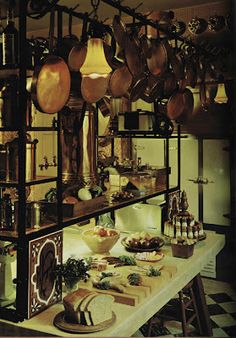 a kitchen filled with lots of cooking utensils and pans hanging from the ceiling