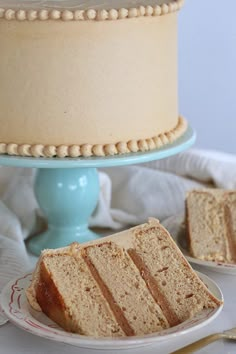 a cake sitting on top of a white plate next to a slice of cake that has been cut