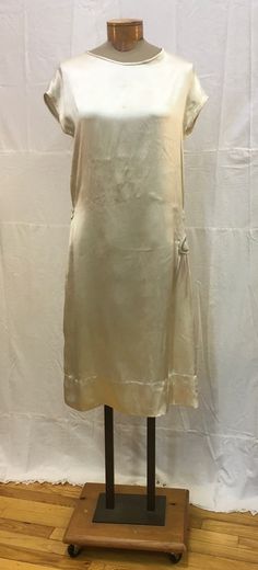 "1920s, 38\" bust, ecru colored silk satin wedding gown with hand beaded , silver and clear crystal beads, flower applique at side right hip.  Skirt of gown is short and straight, narrow band at back of waist.  Gown is sleeveless with an open neckline. Measurements: bust 38\" Waist 34\" Hips 44\" Neckline 9\" wide, 4\" deep Shoulder to shoulder 20\" Shoulder to hem  39\" Arm holes 7\" Width at bottom 52\" Condition very good,  faint round mark at bosom center." Beige Silk Slip Dress For Wedding, Beige Silk Evening Dress, Silk Cream Dress For Vintage Events, Cream Silk Dress For Vintage Events, Beige Slip Dress For Wedding, Cream Dresses With Bias Cut For Vintage Events, Silk Beige Dress For Vintage Events, Silk Beige Dresses For Vintage Events, Beige Silk Dress For Vintage Events