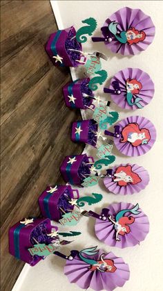 the little mermaid cupcake toppers are purple and green with silver stars on them