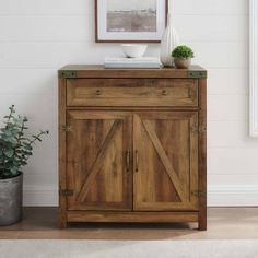 a wooden cabinet sitting next to a potted plant