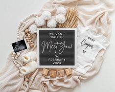 a baby announcement card on top of a blanket next to items from the birth month