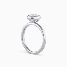 The Tulip Engagement Ring combines modern elegance and timeless design. This ring is a bezel setting that sits taller allowing for straight bands to sit flush. The Tulip Engagement Ring can be set with any size or shape of center stone and is available in 14k or 18k yellow gold, white gold, rose gold or platinum. The price listed includes the setting only. Want more info? Book an appointment to sit down with one of our bridal experts virtually or in-store. Timeless Formal Wedding Jewelry With Smooth Bezel, Modern Platinum Ring With Round Band, Modern Platinum Rings, Timeless White Gold Wedding Ring With Smooth Bezel, Modern White Gold Round Cut Signet Ring, Platinum Emerald Cut Ring With Bezel Setting, Formal Diamond Ring With Smooth Round Bezel, Luxury Rings With Smooth Bezel For Anniversary, Platinum Ring With Single Diamond In Round Band