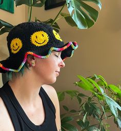 hand crocheted black bucket hat with Smiley Face Emoji detail all around the sides. the slightly floppy brim can be shaped loosely and has a rainbow detail along the edge for a pop of extra color!  stretchy and comfy and cute! Black Crochet Bucket Hat For Beach, Black Wide Brim Crochet Hat, Black Curved Brim Bucket Hat For Festivals, Black Crochet Yarn Bucket Hat, Black Yarn Crochet Bucket Hat, Black Bohemian Crochet Hat Hand Knitted, Black Hand Knitted Bohemian Hats, Black Hand-knitted Bohemian Hats, Black Crochet Wide Brim Hat