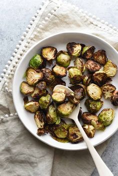 a white bowl filled with brussel sprouts on top of a table