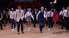 a group of people that are dancing on a wooden floor