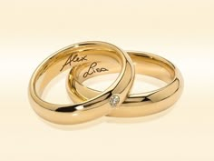 two gold wedding rings with the words alex and iris written on each one in cursive writing