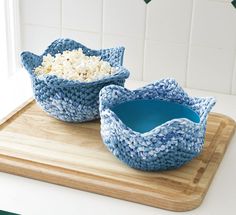 two bowls filled with rice sitting on top of a cutting board