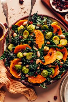 a bowl filled with vegetables and nuts on top of a table next to other dishes