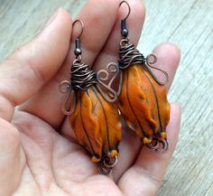 These burnt orange dangle (drop) floral earrings are made of polymer clay and copper. Statement and unique piece of jewelry in warm autumn colors can be a part of your fashion not only this fall, but all over the year. Tender and bright pods will emphasize the individuality of their owner. The earrings can be a beautiful gift for your beloved woman to make her happy. Earring length is about 1.57 inches. Can be made in different colors and sizes. Perfect match to the pendant: https://www.etsy.com Orange Resin Dangle Earrings, Handmade Rust Earrings For Gift, Orange Dangle Resin Earrings, Orange Wire Wrapped Earrings For Gift, Orange Copper Wire Jewelry For Gifts, Orange Copper Wire Jewelry As A Gift, Orange Copper Dangle Earrings, Orange Copper Earrings For Gift, Artisan Orange Copper Earrings