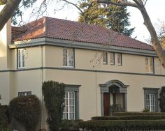 a large house with many windows and bushes