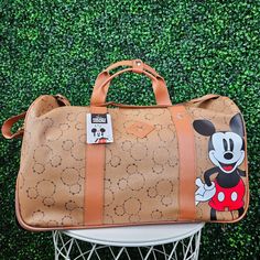 This Brand New 2023 Limited Edition Disney Mickey Mouse 20” Rolling Duffel Bag With Pull Out Handle And Rolling Wheels For Easy Carrying. Material Is A Soft Faux Leather With Handles And Strap, Unique Mickey Constellation Star Head Pattern With A Large Mickey Print In The Front. Perfect For Any Mickey Fan Ready For Its Next Adventure. Bioworld Two Inner Pockets, One Zip Pocket And Bottom Zips Open Soft Faux Leather Telescopic Handle, Wheels 20"L X 10"W X 12 3/8"H We Ship Daily Disney Style Brown Travel Bag, Disney Brown Travel Bags, Disney Travel Bags With Detachable Strap, Disney Suitcase, Disney Duffel Bag, Disney Mickey Mouse Backpack For Travel, Disney Rectangular Travel Bag, Disney Luggage, Playful Minnie Mouse Travel Bag