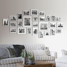 a living room filled with furniture and framed pictures on the wall above it's coffee table