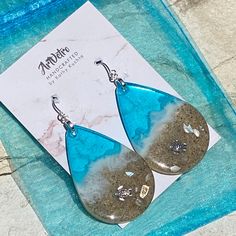 "These realistic beach earrings are made with layers of shimmering translucent resin, real sand and bright colorful inks with a silver plated sea turtle. They are available in 3 sizes. LG 2.5\" x 1.5\" MED 2\" x 1.25 SM 1.5\" x 1\" Please review the dimensions carefully to manage expectations. The large makes a beautiful statement, but are quite big. These are made to order and yours may be slightly different than those pictured." Resin Drop Earrings For Beach, Nickel-free Teardrop Earrings For Beach, Nickel-free Teardrop Jewelry For Beach, Silver Teardrop Earrings For Beach, Resin Dangle Earrings For Beach, Resin Earrings For Summer Beach, Summer Beach Teardrop Earrings, Summer Beach Resin Earrings, Unique Teardrop Jewelry For Beach