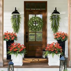 front porch decorated for christmas with wreaths and potted flowers