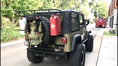 the jeep is parked on the side of the road with its cargo bag strapped to it's back