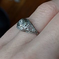 This Art Deco engagement ring has no shortage of charming details. Lacey, beaded scrolls and criss-cross patterns cover the whole top of the ring making it light and airy. It is crowned with a glittering diamond held in place by 8 tiny prongs. It would make an excellent engagement or vintage statement piece! * Art Deco 1930's approximately * 18K White gold * .07ct (approximate) Transitional cut diamond * Size 6.5 - Can be resized within a couple sizes * Very good/excellent condition - Some wear Intricate White Gold And Platinum Jewelry, Platinum White Gold Jewelry With Intricate Design, Platinum Jewelry In White Gold With Intricate Design, Classic White Gold Jewelry With Rose Cut Diamonds, Formal 14k White Gold Filigree Ring, Fine Jewelry Platinum Filigree, Elegant Rings With Intricate Design And Round Band, White Platinum Jewelry With Intricate Design, Victorian Platinum Diamond Ring With Hallmark