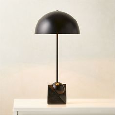 a black lamp sitting on top of a white table