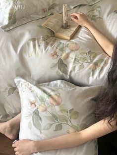 a woman laying in bed reading a book