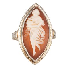 This is part of Chairish’s Fine Jewelry assortment.  Finely detailed vintage Art Deco carved cameo ring (circa 1920s to 1930s) crafted in 14k white gold.   Cameo measures 20mm x 10mm (in good condition and free of cracks or chips).     Carved cameo depicts an elegant woman holding a water vessel in a Grecian style flowing dress. Set into a marquise shaped mount the ring makes a nice statement on the hand. The ring has a low profile and rises 4.5mm from the finger (0.17 inches).    The ring is in Water Vessel, Vintage Cocktail Rings, Masonic Jewelry, Russian Jewelry, Grecian Style, Antique Jewelry Rings, Vintage Cocktail Ring, Flowing Dress, Gold Cocktail Ring