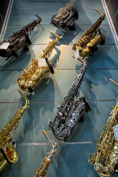 a group of saxophones sitting on top of a blue floor next to each other