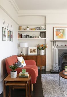 a living room filled with furniture and a fire place in front of a white wall