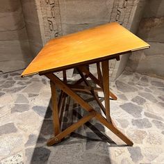 a wooden table sitting on top of a stone floor