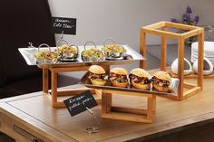 an assortment of pastries displayed on wooden serving trays in front of a counter