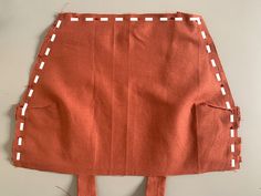 an orange skirt with white stitching on it