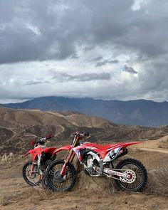 two dirt bikes parked on top of a hill