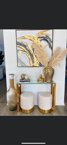 two white stools sitting in front of a painting