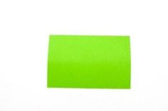 a green piece of paper sitting on top of a white surface