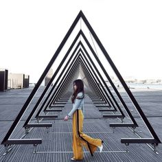 a woman is standing in front of some metal structures