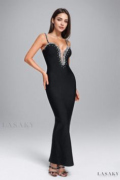 a woman in a black evening gown with beading on the neck and shoulders, posing for