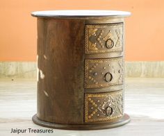 an ornate wooden table with four drawers on the top and bottom, in front of a tan wall