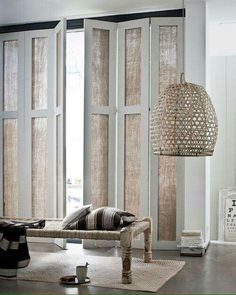 a living room with sliding glass doors and rugs on the floor in front of it