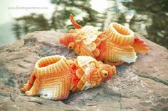 two crocheted fish shoes sitting on top of a rock