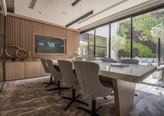 a conference room with chairs and a large table in front of a flat screen tv