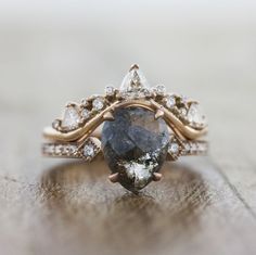 a close up of a ring with a large stone in the middle and small diamonds around it