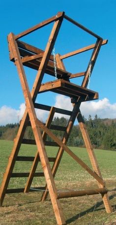 a wooden swing set in the middle of a field