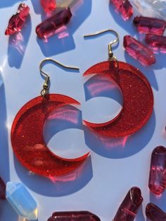 These ruby-red crescent moons are made of a richly colored glitter acrylic and almost glow as light shines through them. Super lightweight and make a great statement!  Available in a small and large version. Interested in a more subtle moon? Check out the clear rainbow iridescent moons on my shopfront, along with other colors! These earrings are approximately 2" long (small) and 2.5" long (large). ★ GIFT-BOX & WRAPPING AVAILABLE IN CHECKOUT ★ SWAP CLOSURE TYPE: fish hook, lever back, and studs a Red Plastic Party Jewelry, Plastic Round Jewelry For Parties, Round Plastic Party Jewelry, Red Glitter Jewelry For Party, Red Plastic Earrings For Gift, Handmade Red Plastic Earrings, Handmade Crescent Jewelry For Parties, Red Round Resin Jewelry, Red Resin Round Jewelry