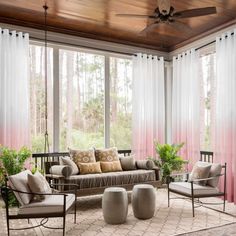 a living room filled with lots of furniture next to a window covered in blue drapes